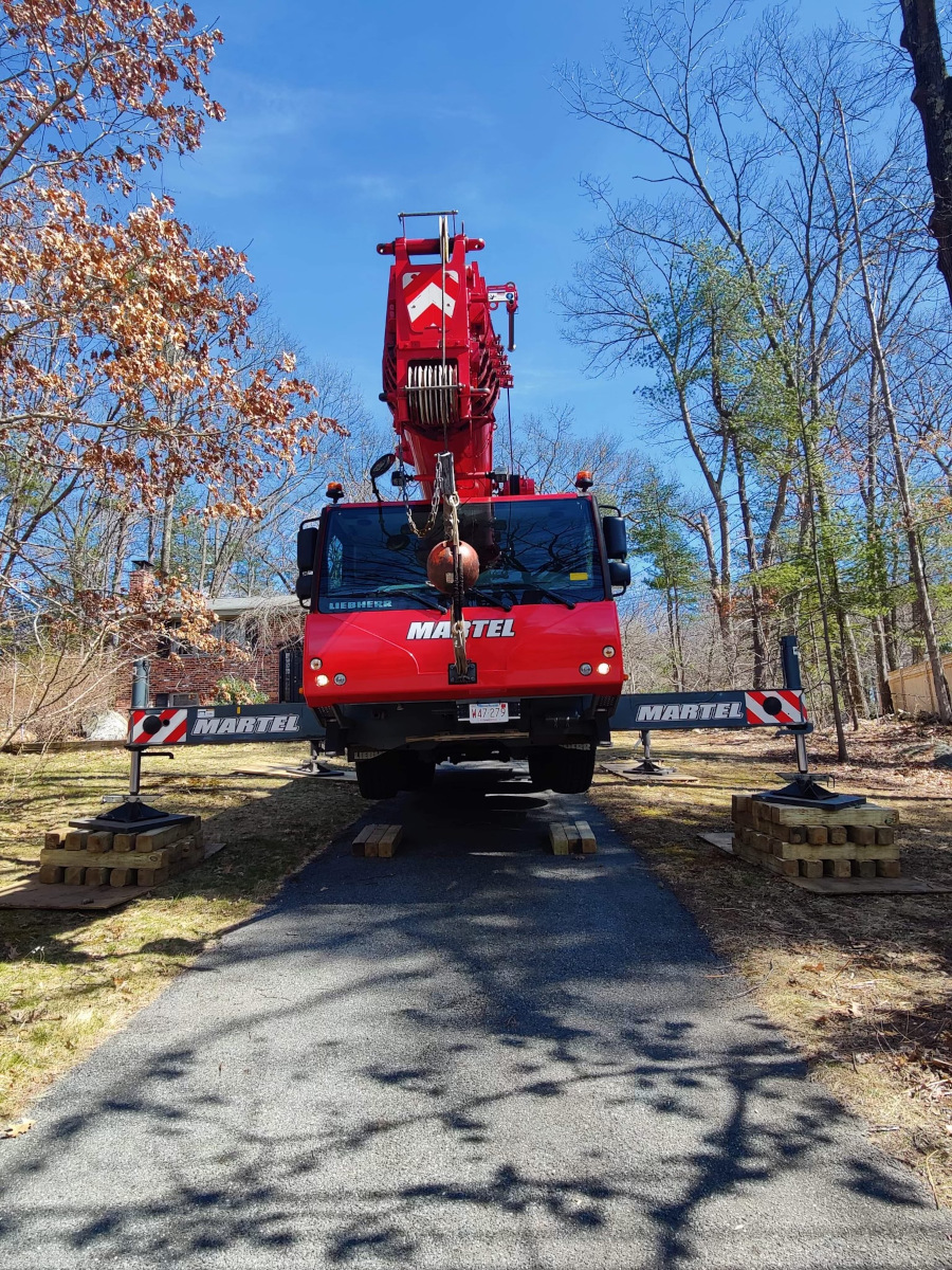 We setup the red crane in the driveway of this residence in Chelmsford, MA to safely remove trees from the property.