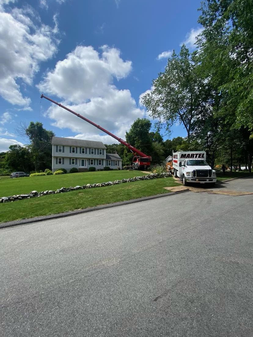 The crew from Martel Crane & Tree used the red crane to safely remove trees from this property in Chelmsford, MA.

