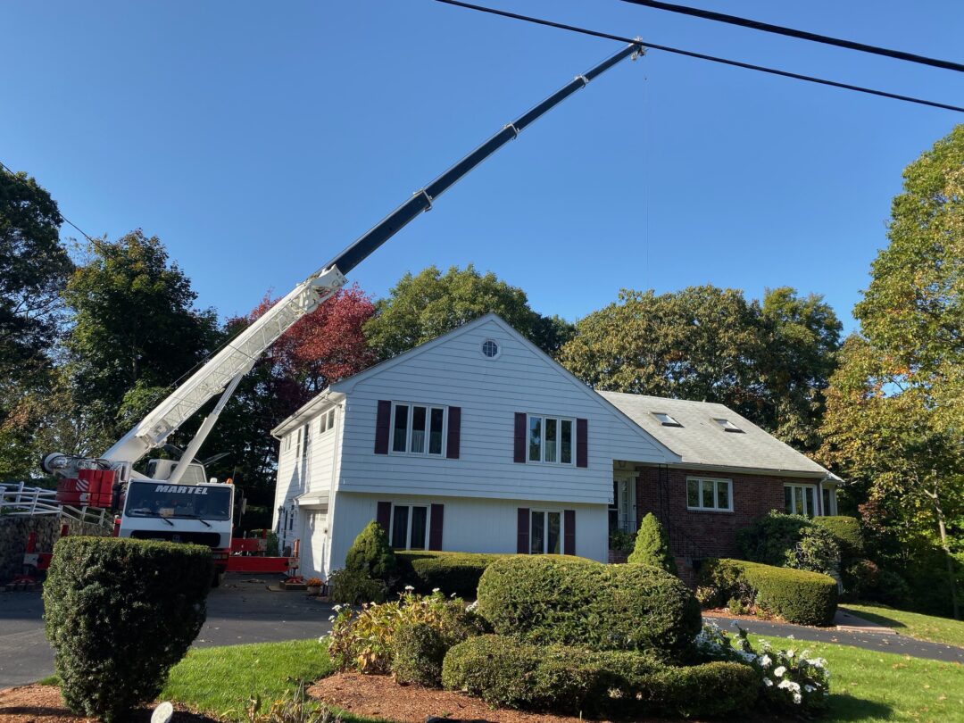 The crane had to stretch out to 100' to safely remove this large oak tree in Winchester, MA, by Martel Crane Service & Tree Removal