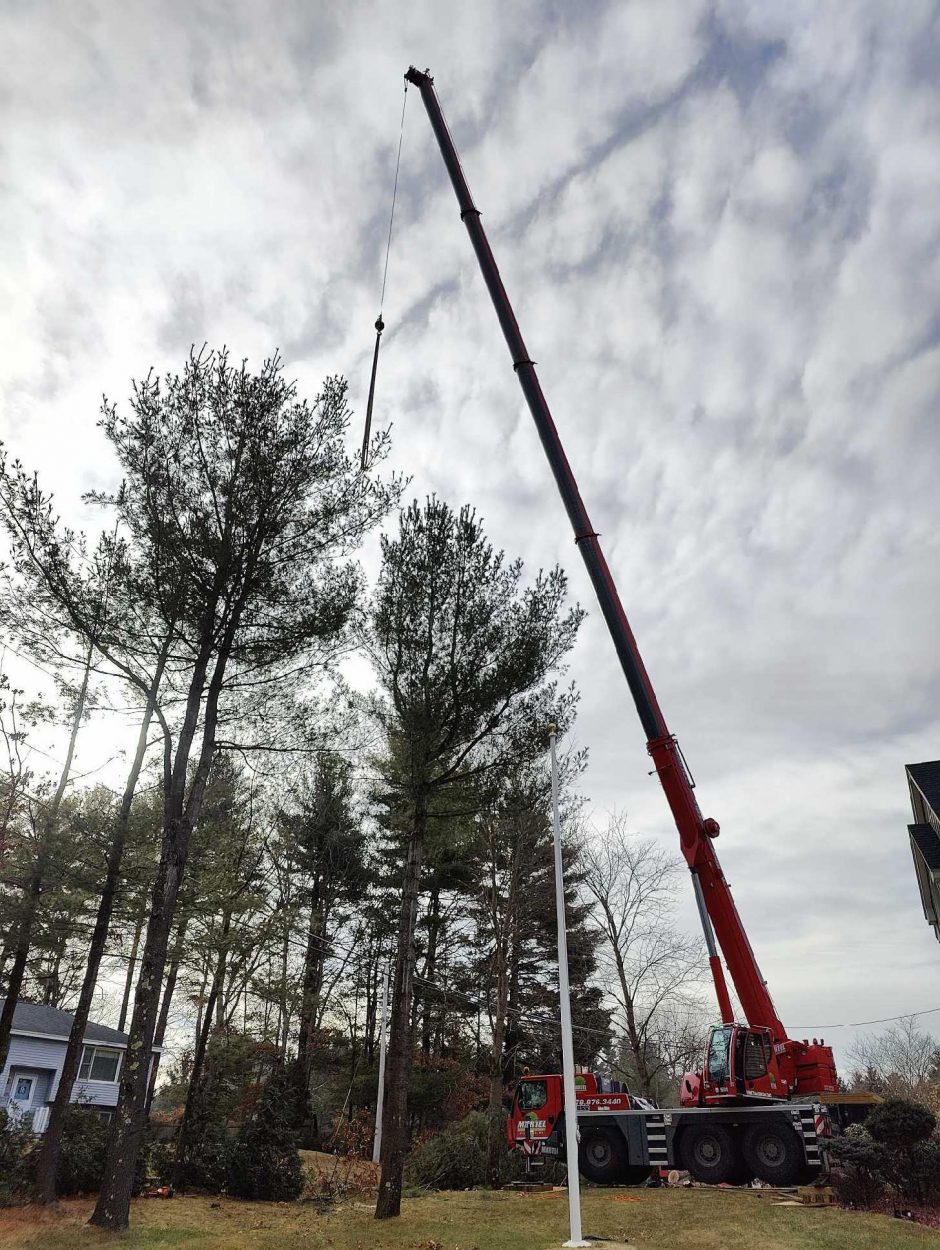 The crew and red crane from Martel Crane and Tree Service removed tall pines from this residence in Tewksbury, MA.
