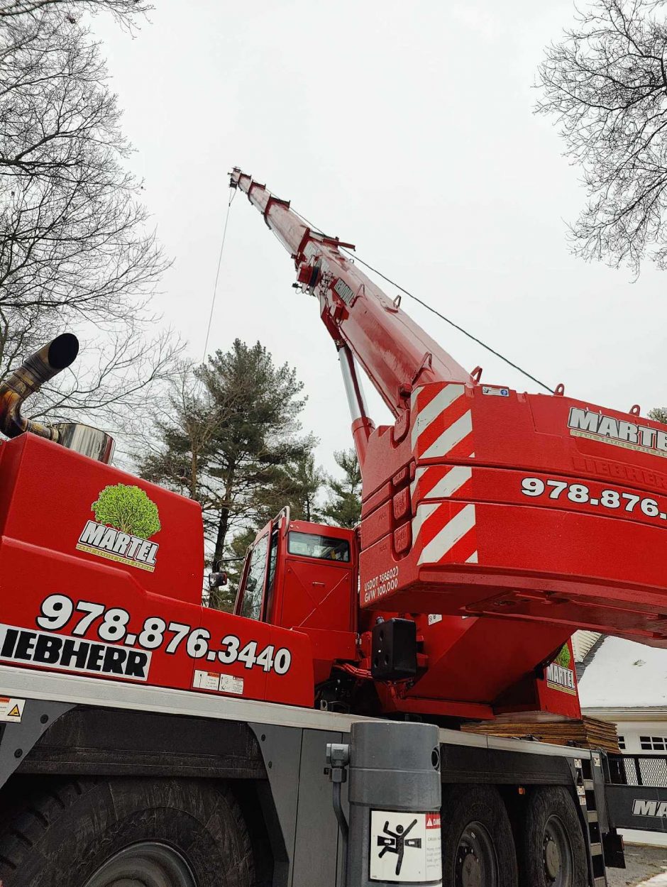 For this tree removal job in Chelmsford, MA, Martel Crane and Tree used the reach of the red crane to safely remove trees from the property.

